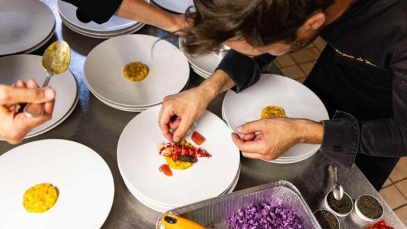 Un chef dressant avec précision un plat de homard et de caviar pour une expérience gastronomique française d'exception en cuisine