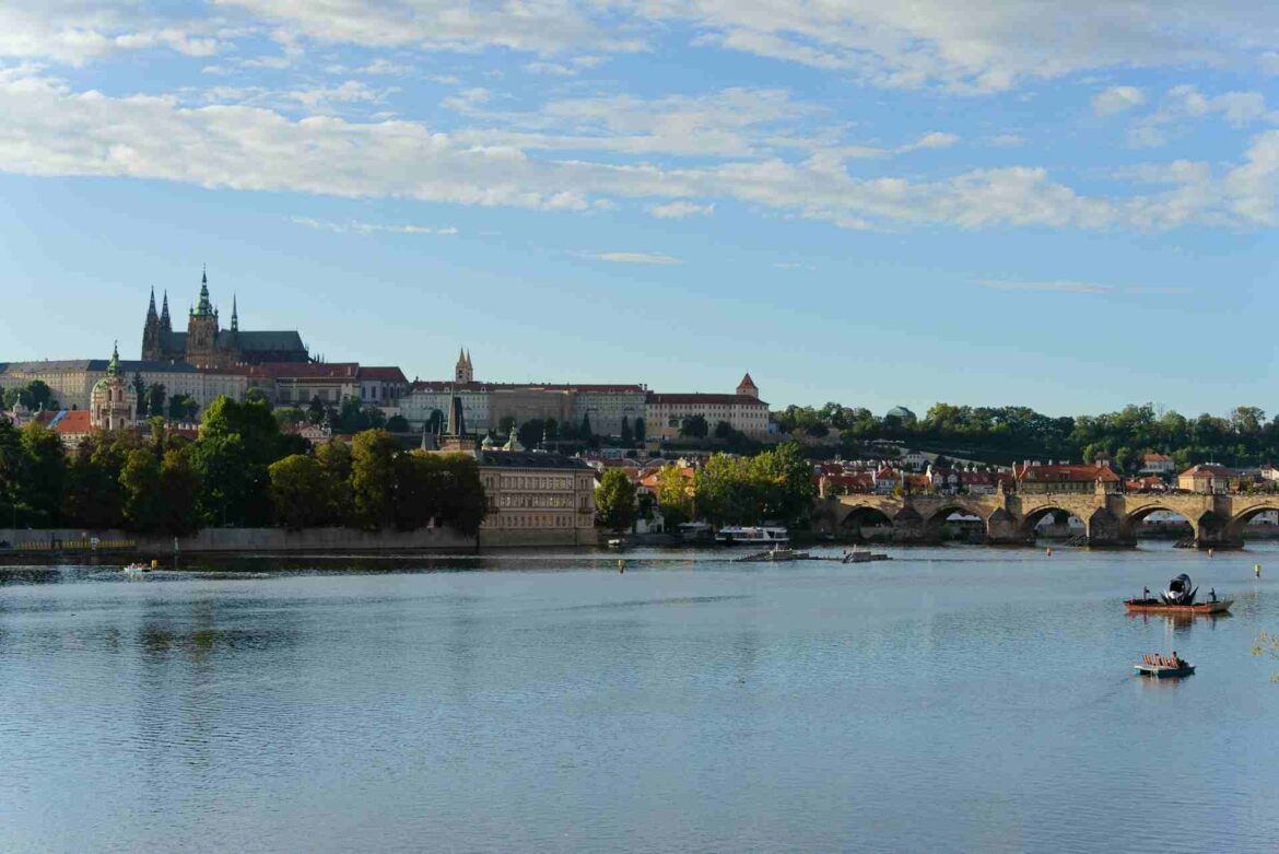 Vue panoramique de Prague depuis la rive de la Vltava, avec le pont Charles et le château.