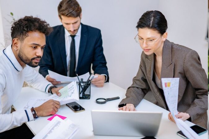 Des professionnels studieux examinent des documents et discutent des demandes des clients.
